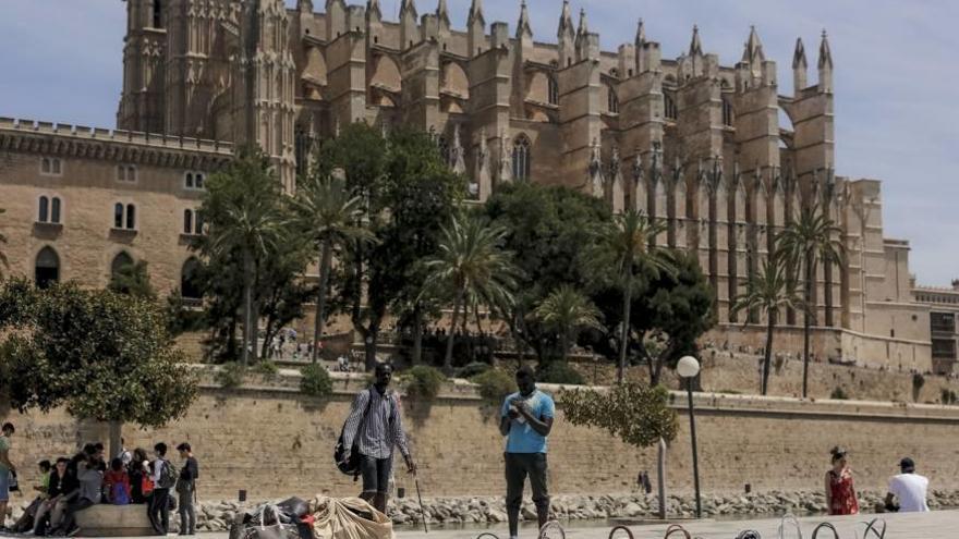 Vendedores ambulantes ilegales en la zona portuaria situada frente a la Seu.