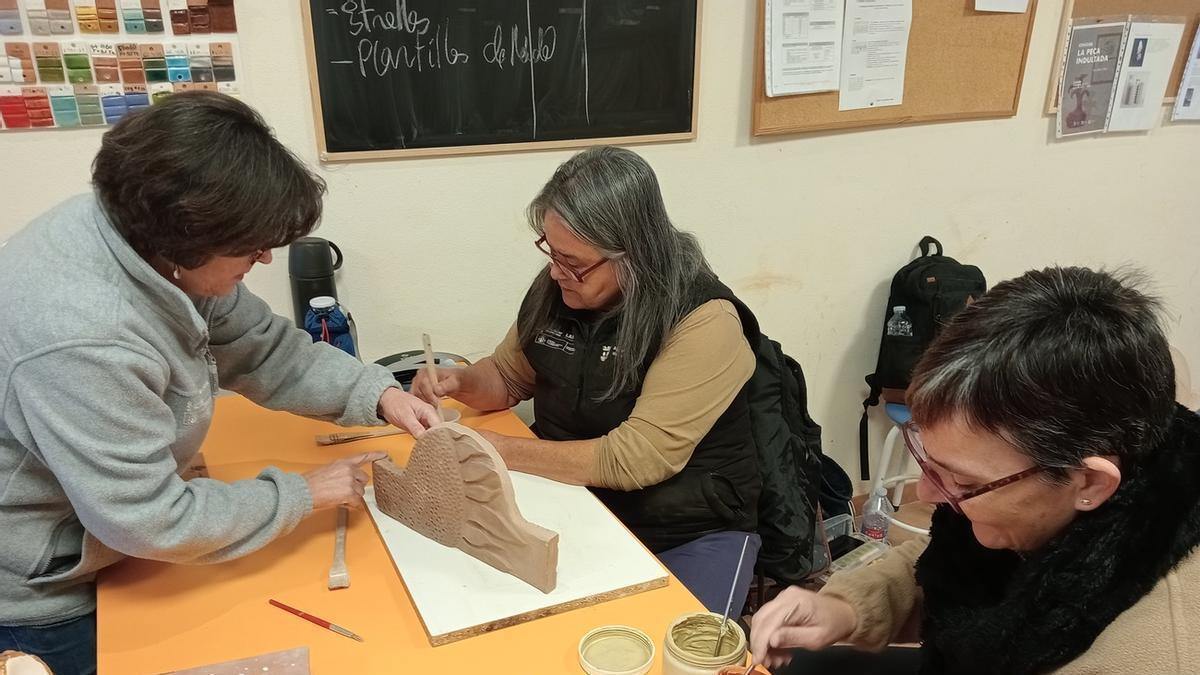 La coordinadora y dos participantes en un taller ocupacional de cerámica en Potries