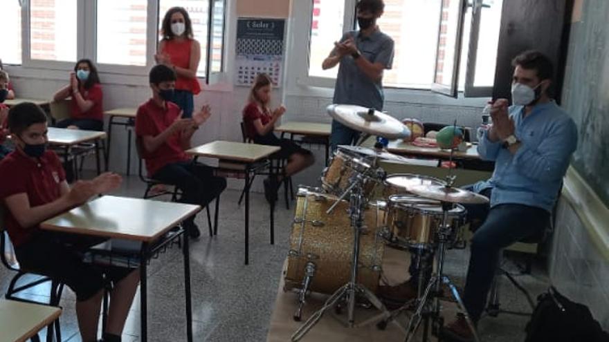 Alejandro Espín tocando la batería siguiendo el ritmo de los aplausos de los alumnos.