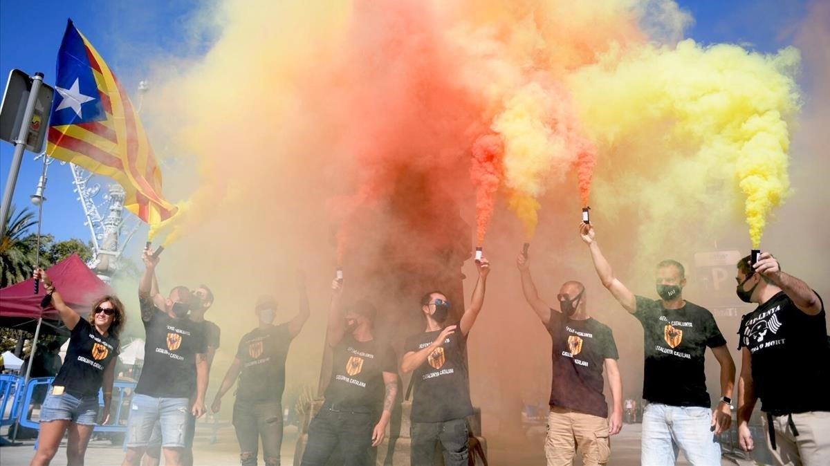 Simpatizantes de Òmnium queman unas bengalas con los colores de la senyera antes de iniciarse el acto en el passeig Lluis Companys.