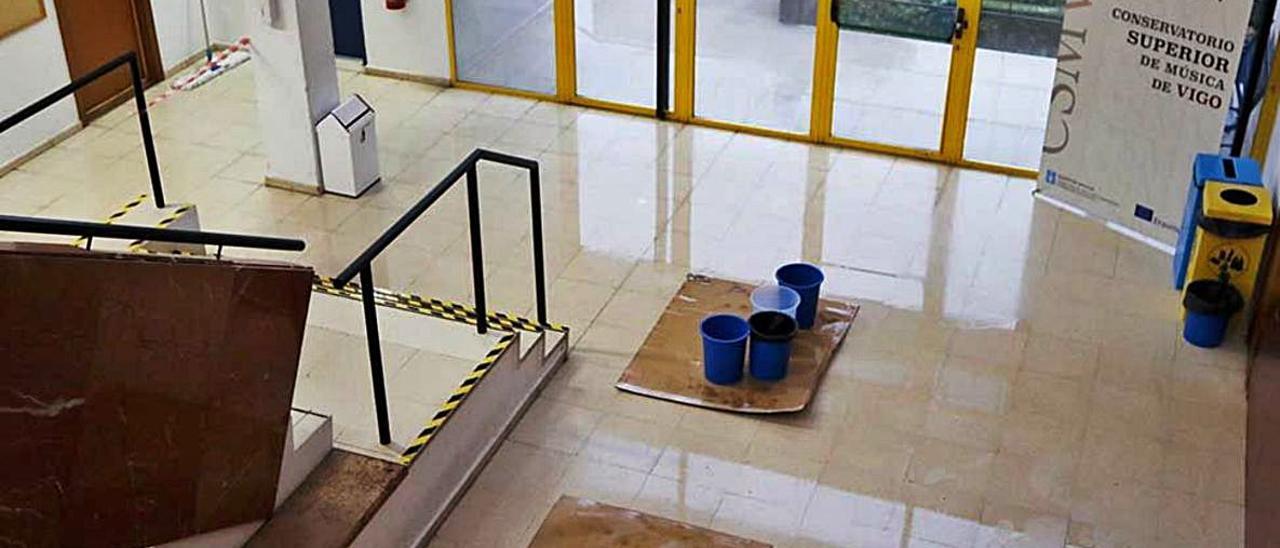 Cubos y cartones a las puertas del edificio, para recoger agua.  | // FDV