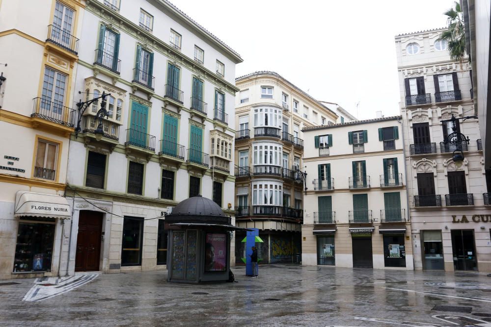 Pasan los días de confinamiento y la situación de la ciudad sigue siendo desértica. La siempre frecuentada calle Larios, la Alameda, principal vía de tráfico tanto privado como público del centro de la ciudad, y el bullicioso mercado de Atarazanas presentan durante el estado de alarma provocado por la pandemia de coronavirus una imagen inusual, acentuada por la persistente lluvia de esta semana.