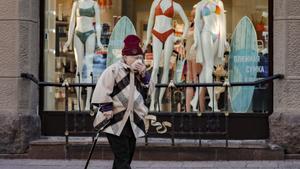 Una mujer con mascarilla camina por una calle comercial de Moscú.