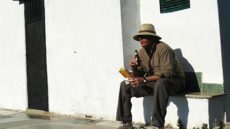 Un llaurador almuerza mientras riega