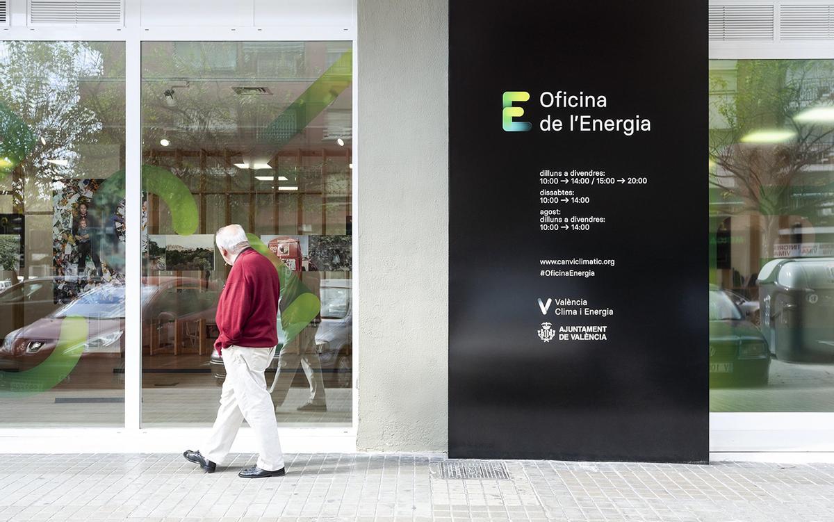 Una persona mayor pasa por delante de una de las Oficinas de la Energía de València.