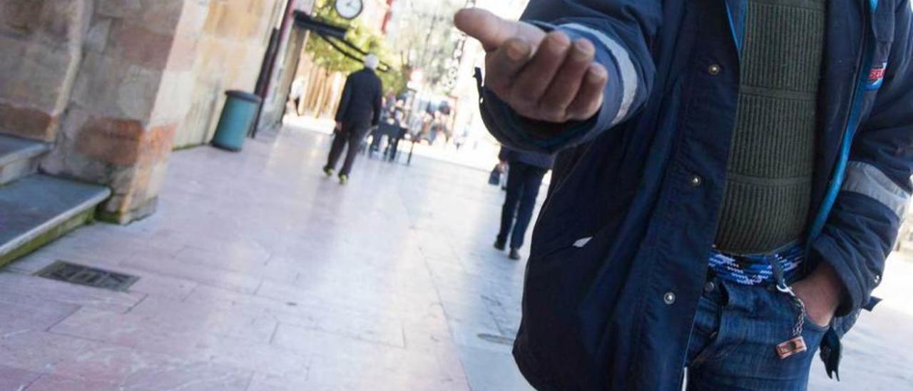 Un hombre, pidiendo lismona ayer en la plaza Porlier.