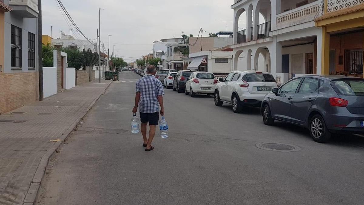 Un vecino de Almenara carga con dos garrafas de agua al trascender la incidencia en el suministro del agua potable.