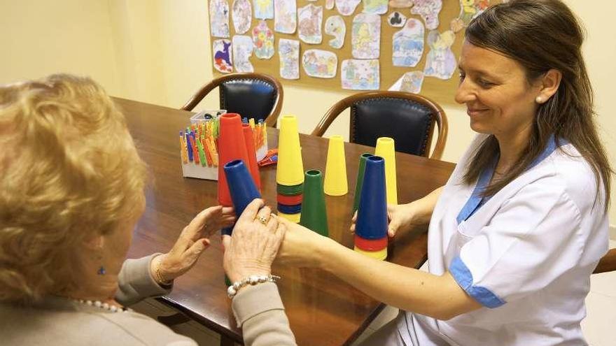 Una mujer participa con una terapeuta en un taller de estimulación cognitiva.