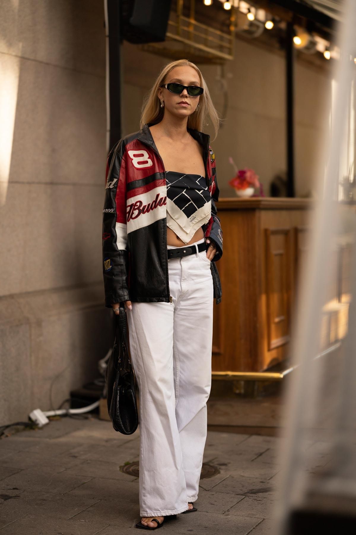 Estilismo con chupa de cuero combinada con top pañuelo y pantalones anchos visto en el 'street style' de Estocolmo