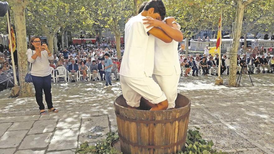 Dos jóvenes ´vermadors´ pisan la uva para producir el mosto joven.