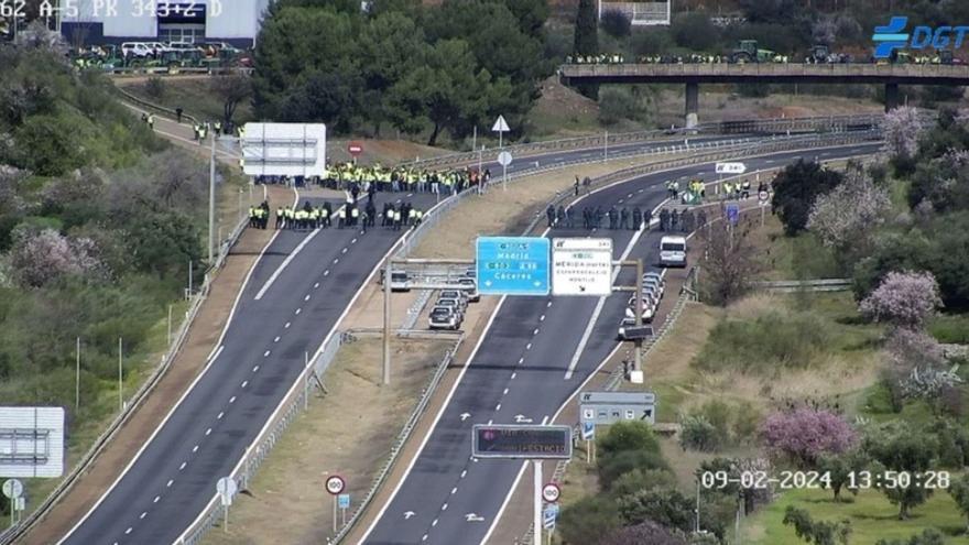 Los manifestantes y los agentes antidisturbios en la autovía A-5 durante el corte del tráfico. | DGT