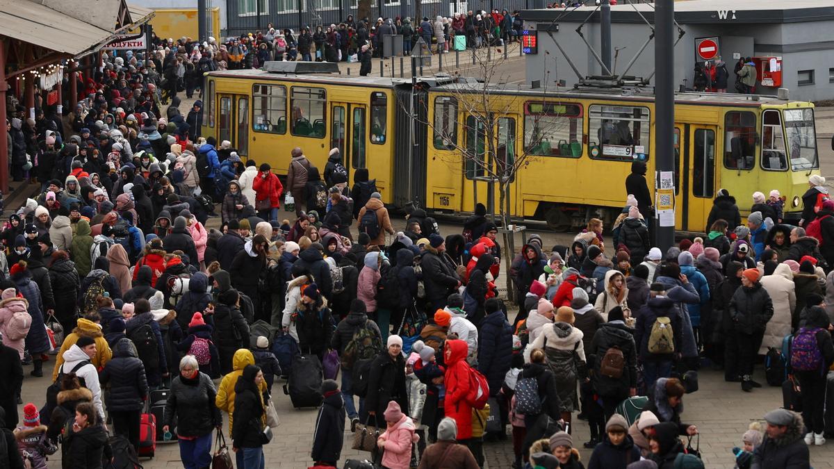 Refugees wait for their transfer to Poland at the train station in Lviv