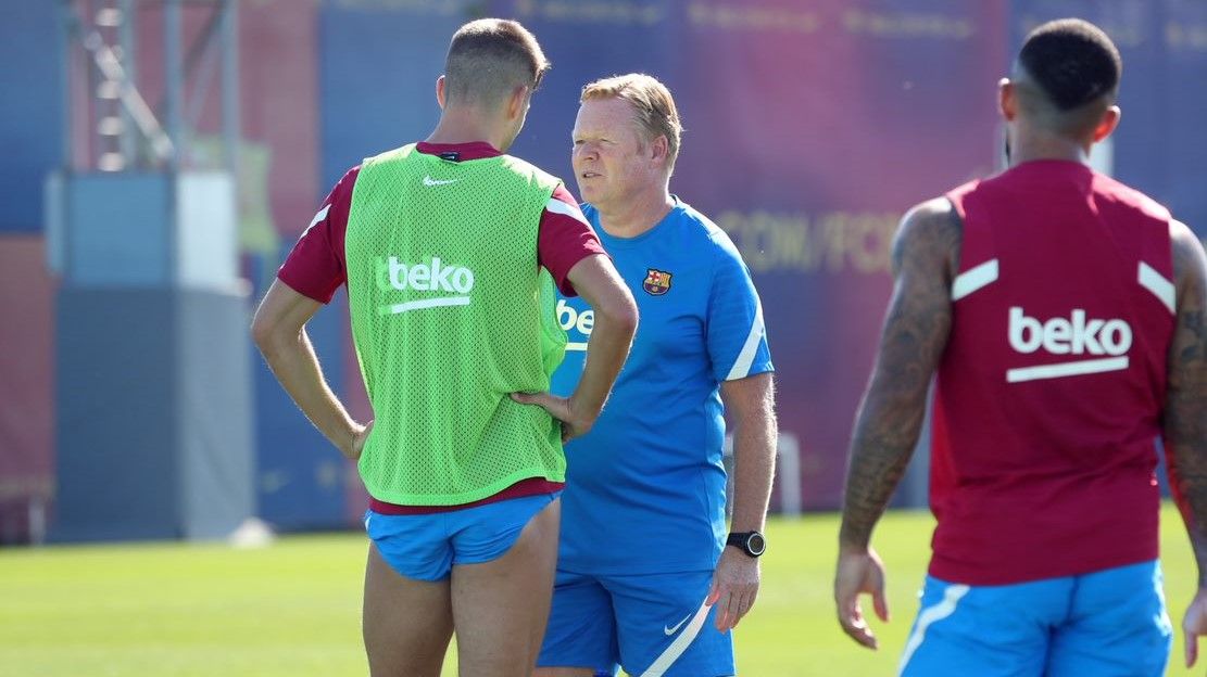 Koeman habla con Piqué con Depay mirando la conversación.