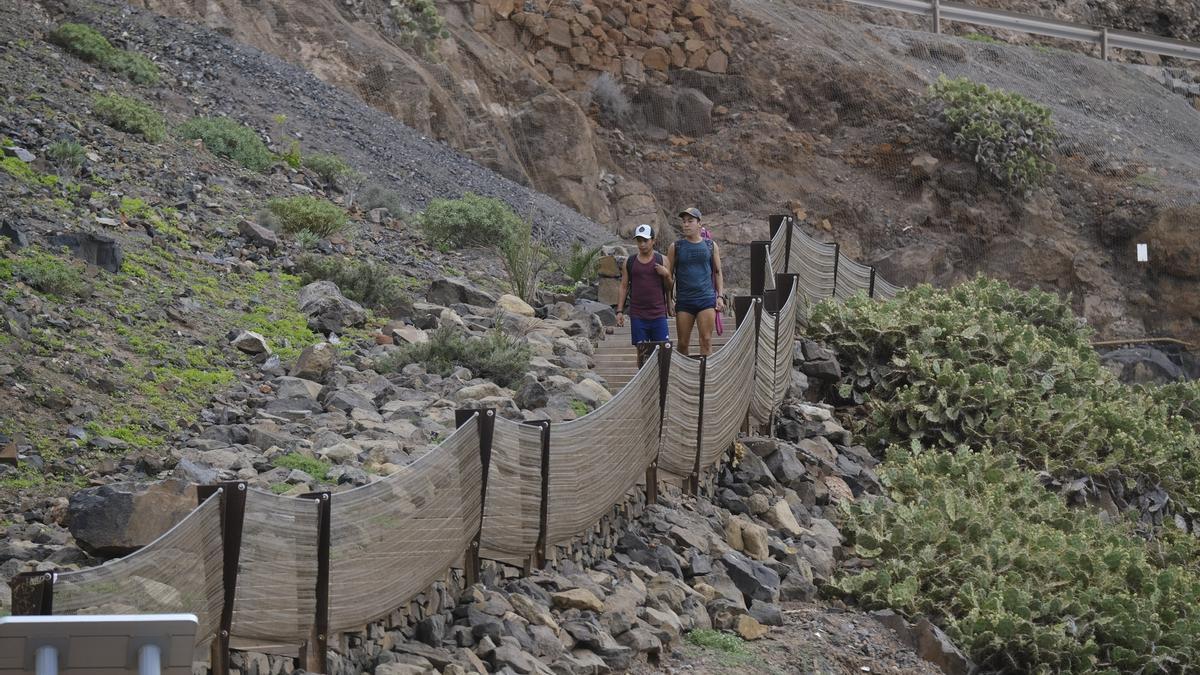 Imagen de dos viandantes accediendo a la playa de El Confital.