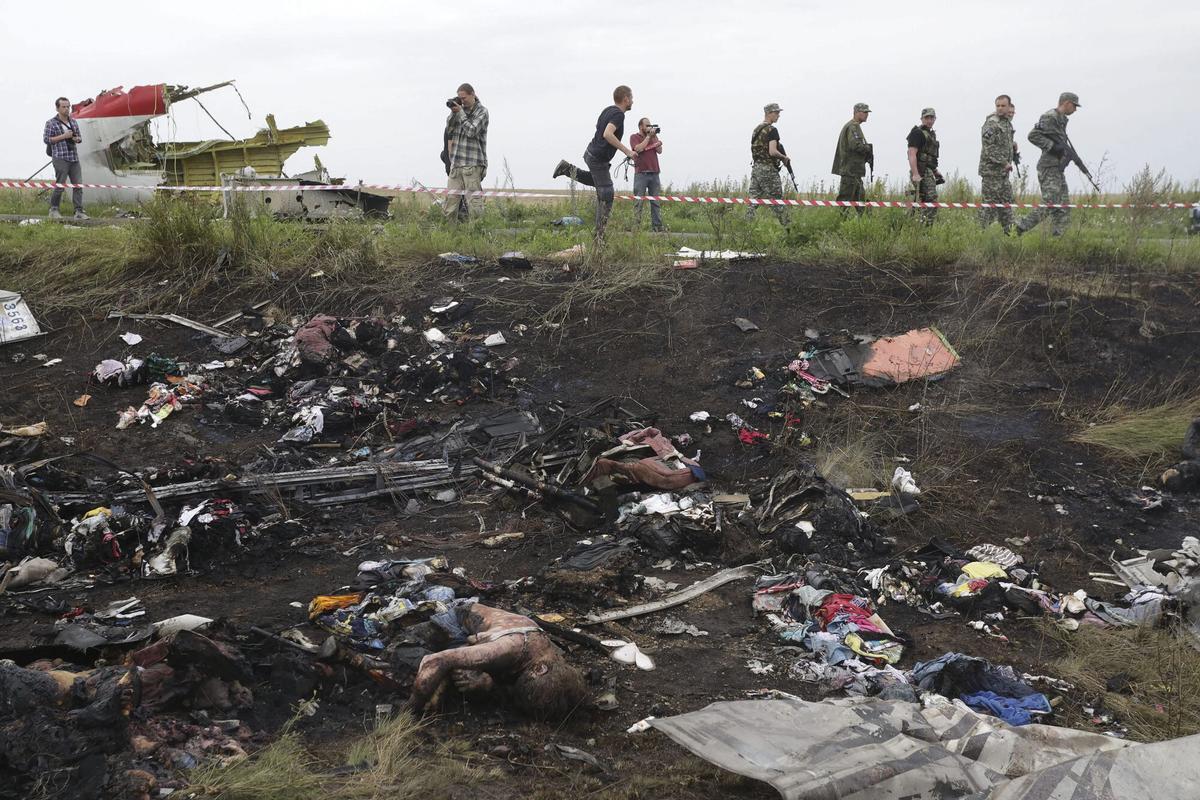 KIV05 DONETSK (UCRANIA) 18/07/2014.- Vista de varias víctimas y restos de fuselaje del avión Boeing 777 del vuelo MH 17 de la aerolínea Malaysia Airlines tras estrellarse cerca de Donetsk (Ucrania) hoy, viernes 18 de julio de 2014. La aerolínea malasia Malaysian Airlines confirmó que 298 personas, cuatro más que las indicadas anteriormente, viajaban en el avión siniestrado en el este de Ucrania, informaron hoy los medios locales. El avión, que realizaba la ruta Amsterdam-Kuala Lumpur, cayó en la región oriental de Donetsk, escenario de combates entre las fuerzas gubernamentales de Ucrania y los rebeldes prorrusos, quienes nada más producirse se acusaron mutuamente de ser responsables del derribo del aparato. EFE/Anastasia Vlasova ATENCIÓN EDITORES AL CONTENIDO GRÁFICO LUGAR DEL ACCIDENTE DEL VUELO MH 17 DE MALAYSIA AIRLINES. ATENCIÓN EDITORES AL CONTENIDO GRÁFICOACCIDENTE DE UN AVION BOEING 777 DE MALASYA AIRLINES QUE CUBRIA LA RUTA ENTRE AMSTERDAM Y KUALA LUMPUR SOBRE LA REGION DE DONETSK, CON EL RESULTADO DE 298 MUERTOS. LAS AUTORIDADES DE UCRANIA Y LOS REBELDES PRORRUSOS SE ACUSAN MUTUAMENTE DE DERRIBARLO CON UN MISIL. VUELO MH17. DERRIBO. CUERPOS. CADAVERES.