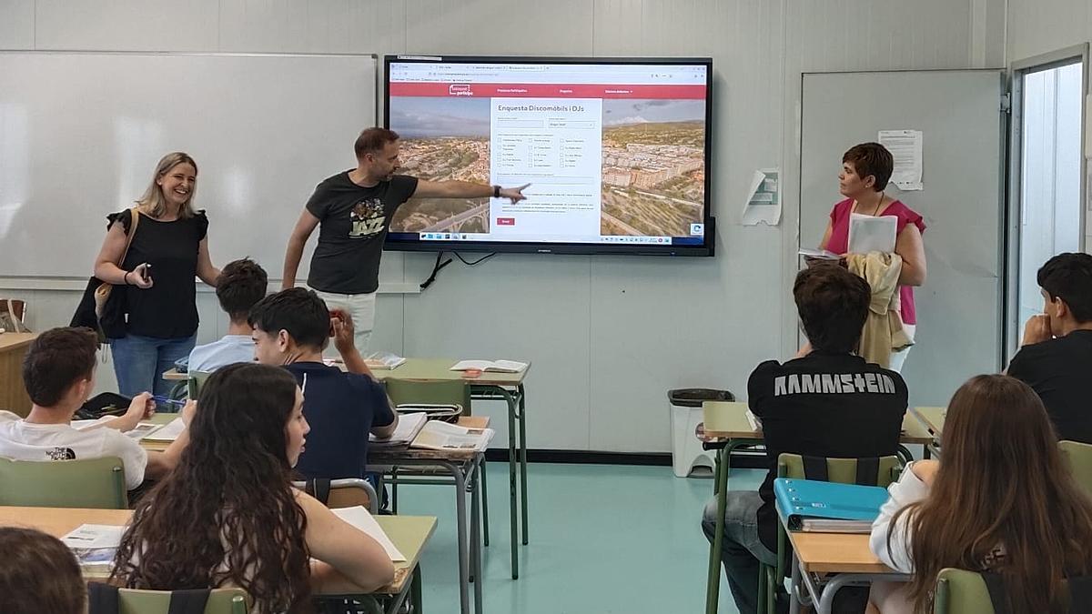 Los regidores de Juventud y Participación exponen las encuestas a una clase de alumnos de un centro educativo.