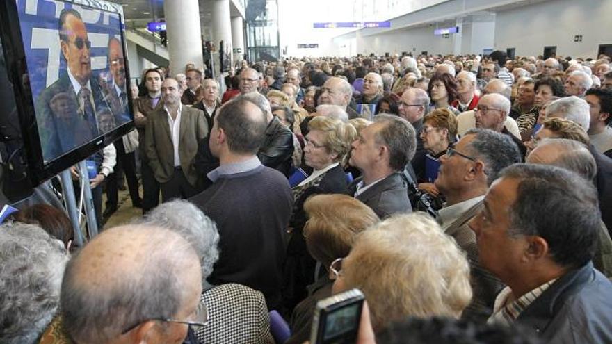 Vecinos de los pueblos colindantes a Vilanova d&#039;Alcolea, donde se ubica el aeropuerto de Castellón, siguen a través de monitores las intervenciones en el acto de inauguración de las instalaciones aeroportuarias.