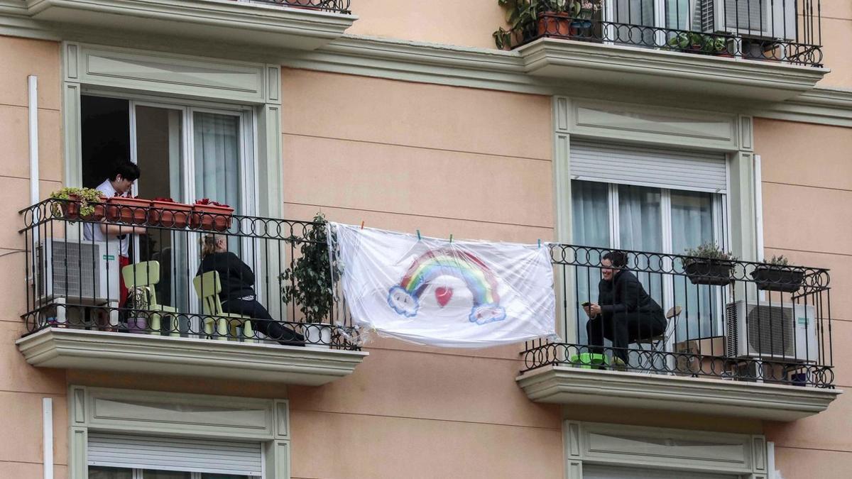 Unas vecinas se comunican de balcón a balcón, durante el confinamiento en Valencia, el 2 de abril.