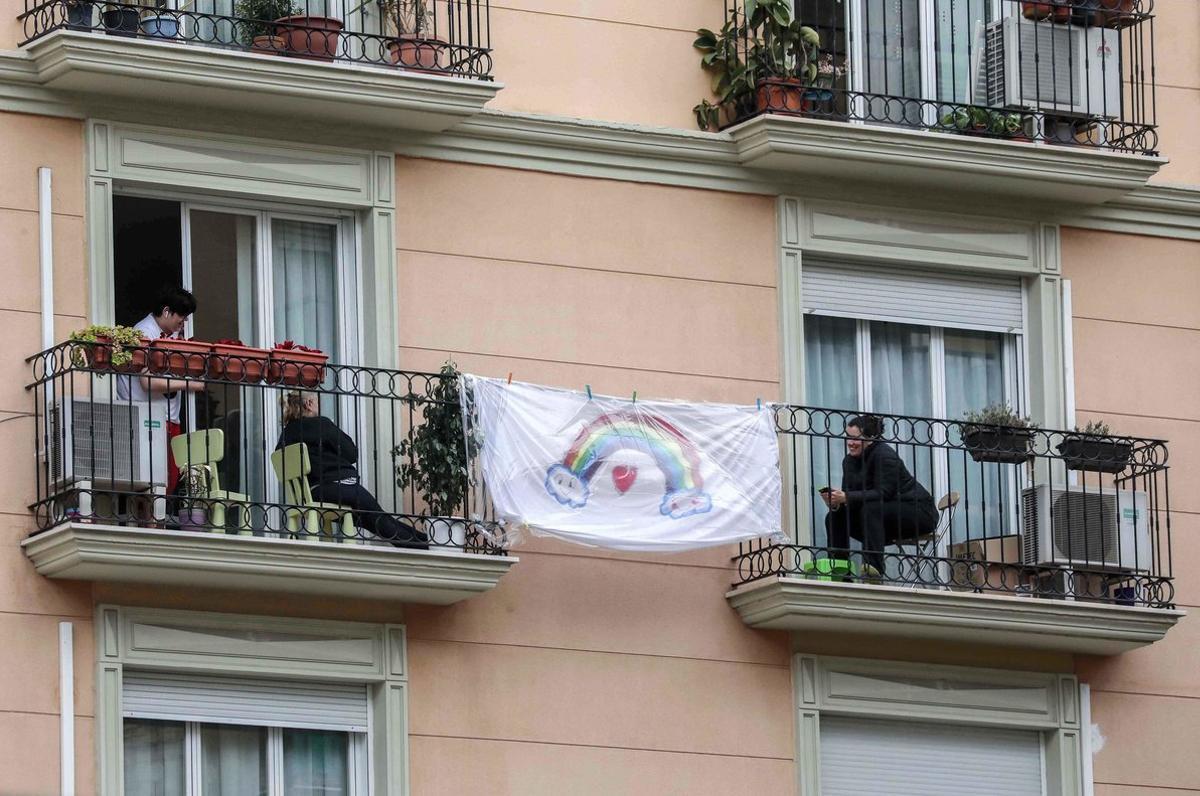 Unas vecinas se comunican de balcón a balcón, durante el confinamiento en Valencia, el 2 de abril.