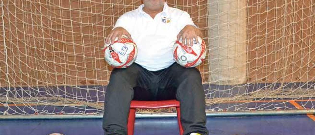 El entrenador Miquel Vidal posa con balones de fútbol sala en la pista del pabellón de Galatzó (Calvià).