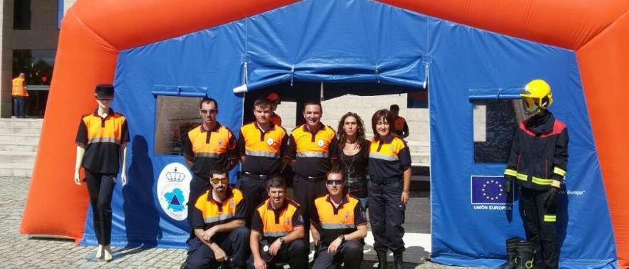 Miembros de Protección Civil de Cangas, recibiendo el hospital de campaña en la AGASP. // FdV