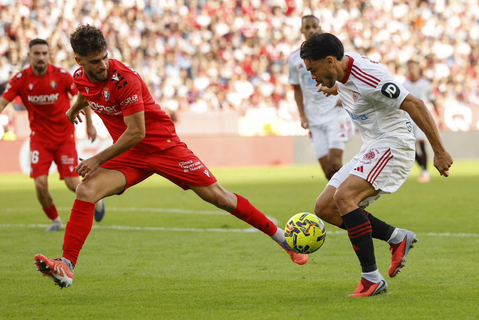 El defensa del Sevilla Gabriel Suazo (d) disputa un balón con el centrocampista del Osasuna Iker Muñoz (i) durante el encuentro correspondiente a la jornada 12 de LaLiga entre Sevilla FC y CA Osasuna celebrado en el estadio Ramón Sánchez-Pizjuán de Sevilla. EFE/ Julio Muñoz. (sEVILLA) (OSASUNA)
