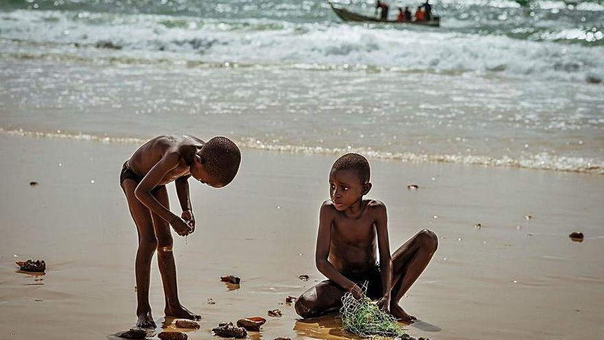 Dos nens busquen petxines a la platja del Senegal el 2014 | ROGER LLEIXÀ