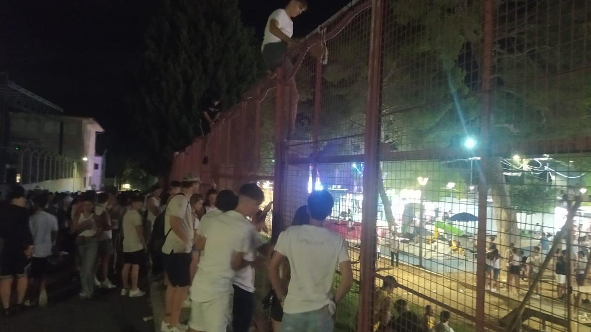 Jóvenes saltando la valla para entrar en el recinto de la verbena de Sant Agustí, en Felanitx