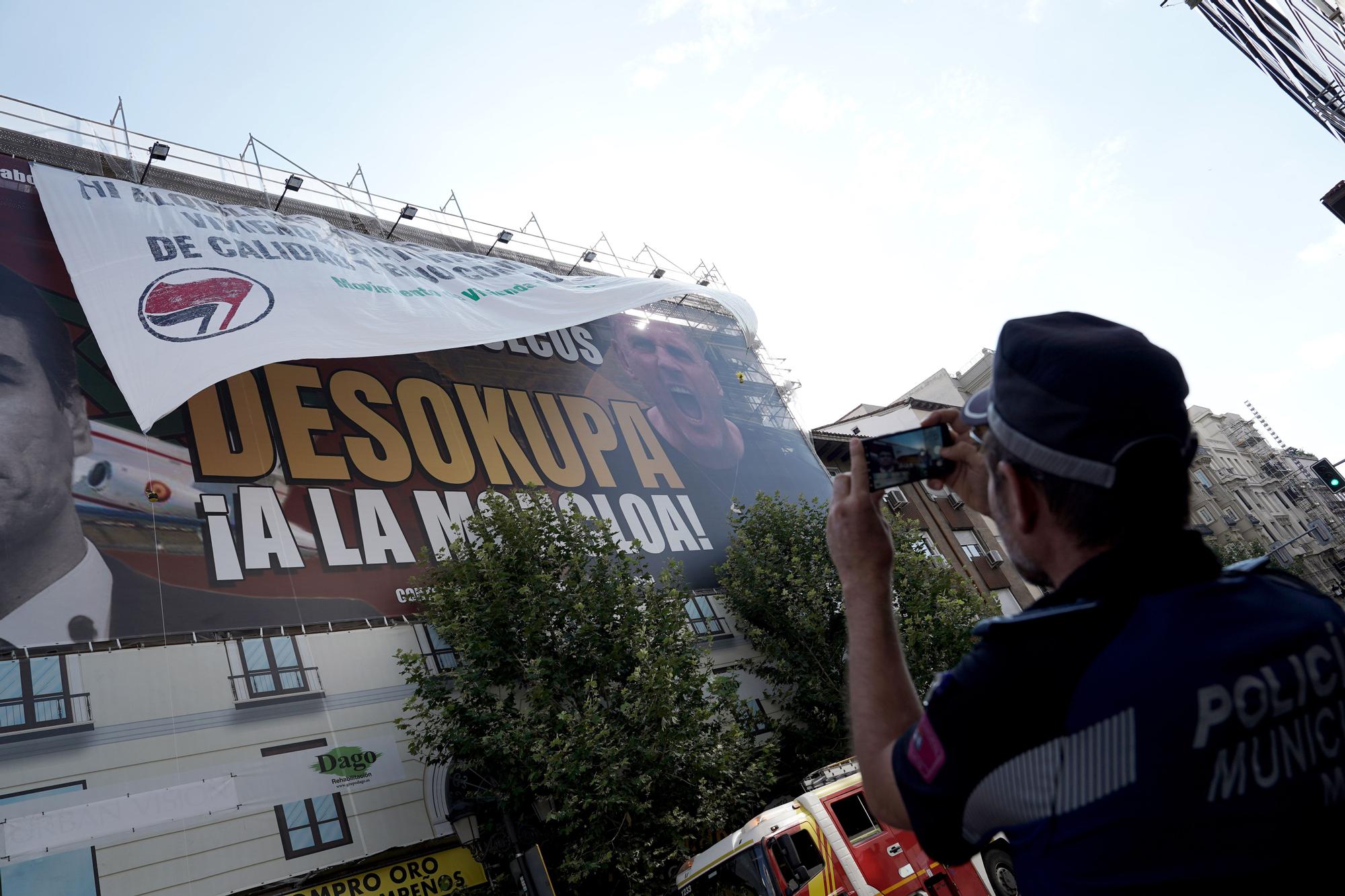 La colocación de una pancarta sobre la lona de Desokupa en Madrid, en imágenes