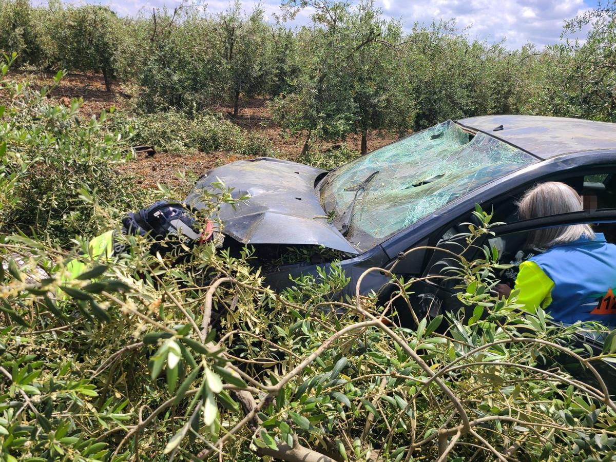 Una sanitaria atiende a la víctima del accidente en su vehículo instantes después de llegar al lugar del suceso cerca de Alvarado (Badajoz).