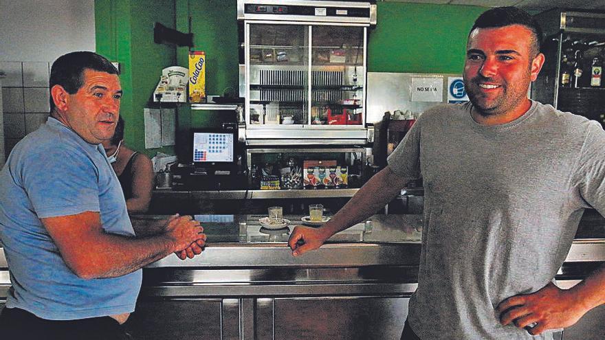 Los agriculturoes Andrés Almeida y Jorge Camacho, a la izquierda, en el interior de la Cafetería Europlátano donde compartían impresiones sobre el volcán. 