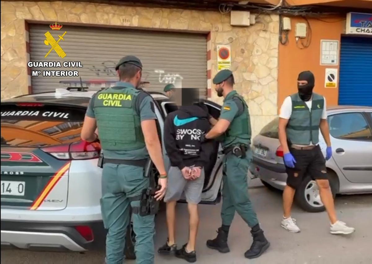 Varios agentes trasladan a uno de los acusados.
