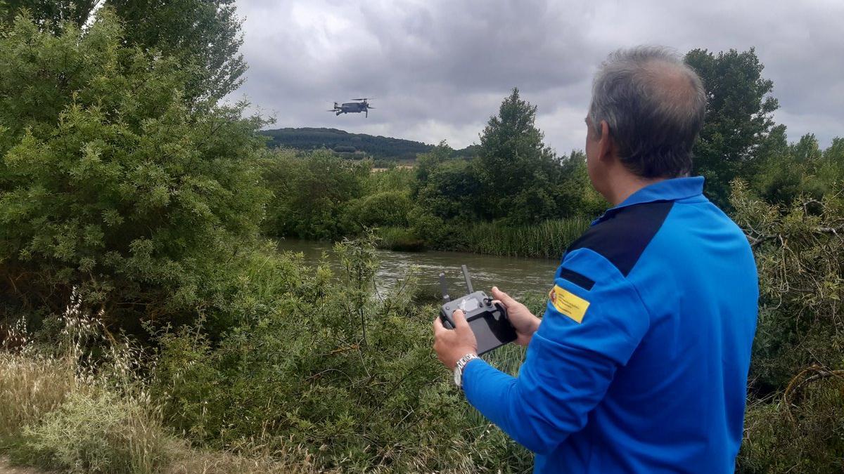 Un agente medioambiental de la CHE realiza labores de reconocimiento del río con un dron.