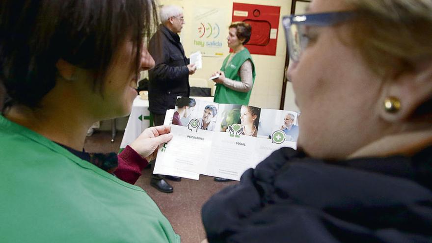 Una de las voluntarias explica el folleto a una zamorana en el centro de salud Santa Elena.