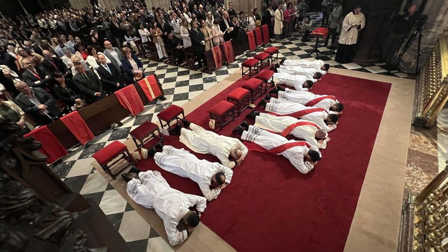 Los cuatro sacerdotes (delante) y los seis diáconos, ayer, postrados ante el altar de la Catedral de Oviedo durante las letanías. | JUAN PLAZA