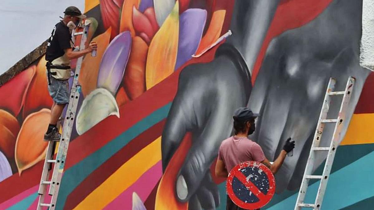 The artists Víctor Pacheco and Acaymo Padrino making the mural.