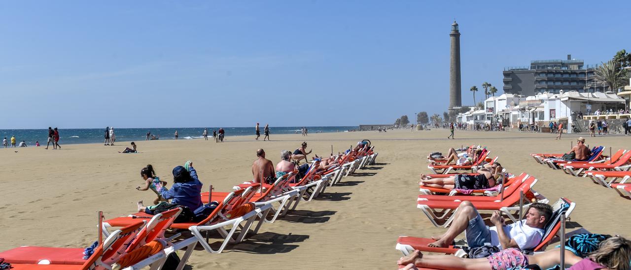 Turistas toman en sol en Maspalomas tras la colocación de las hamacas el pasado mes de febrero.