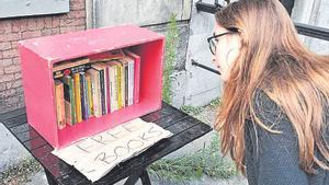 Una joven observa una caja con libros ‘libres’ en Ámsterdam.