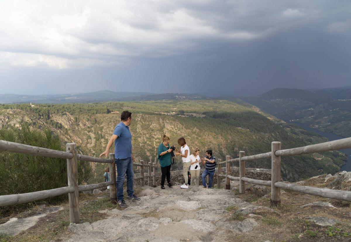 Turistas visitan uno de los paisajes de la Ribeira Sacra.