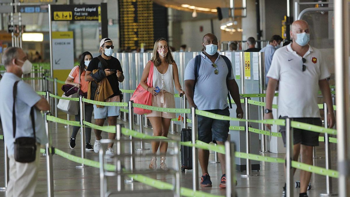 Un grupo de turistas se dispone a pasar el control previo al embarque en el aeropuerto de Manises durante el pasado verano. | DANIEL TORTAJADA