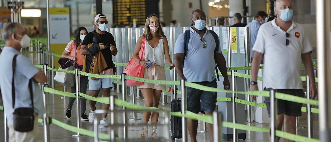 Un grupo de turistas se dispone a pasar el control previo al embarque en el aeropuerto de Manises durante el pasado verano. | DANIEL TORTAJADA