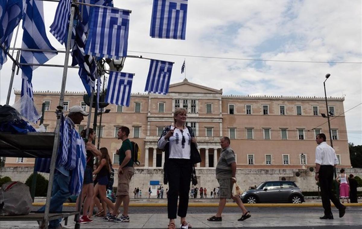 Un vendedor ambulante vende banderas griegas frente al parlamento griego, en Atenas.