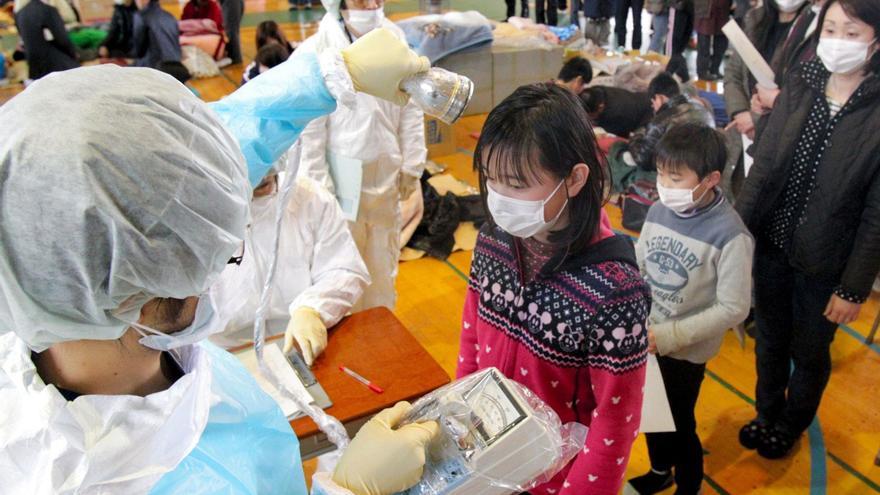 Personal médicomidiendo la radiación enresidentes en Fukushima en 2011