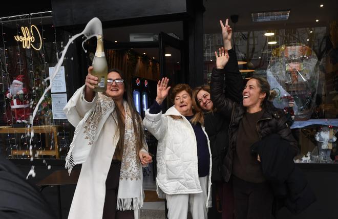 Propietaria y clientas de Forno dos Rosales en A Coruña celebran el tercer premio de la Lotería de Navidad.