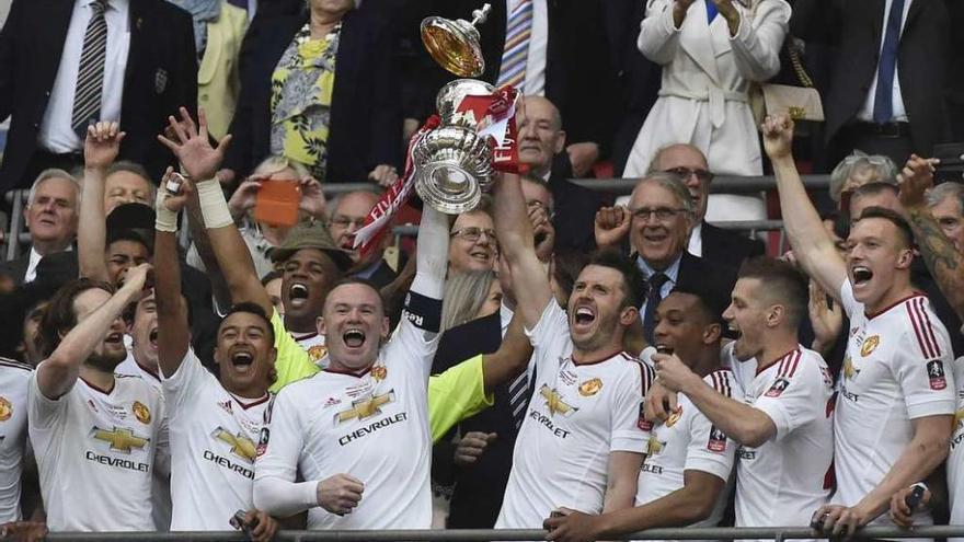 Los jugadores del Manchester United levantan el trofeo en Wembley. // Efe