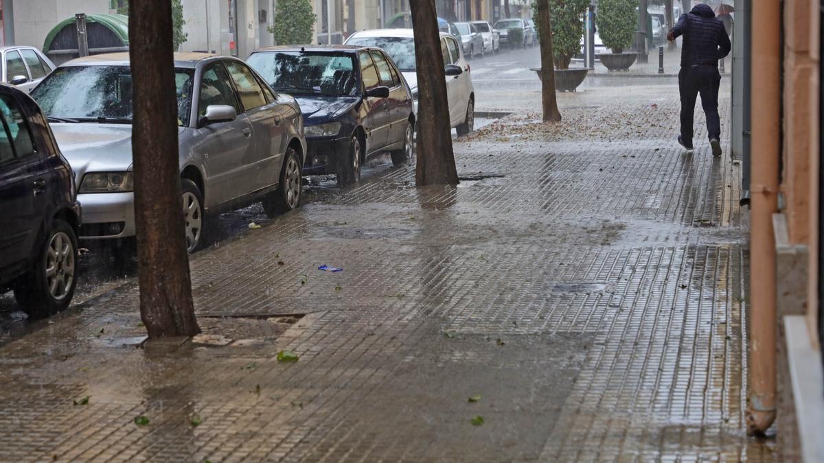 Un hombre se refugia de la intensa lluvia en Gandia.