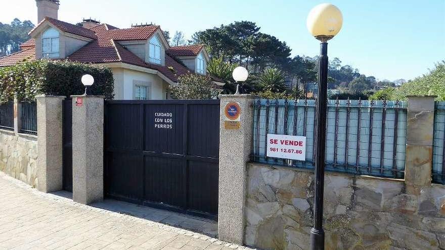 El chalé de la esquina de la playa de Bastiagueiro, ayer con el cartel de se vende y el teléfono de Costa Coruña.