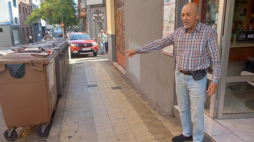 La barbería de Miguel, con trece contenedores de basura por fuera.