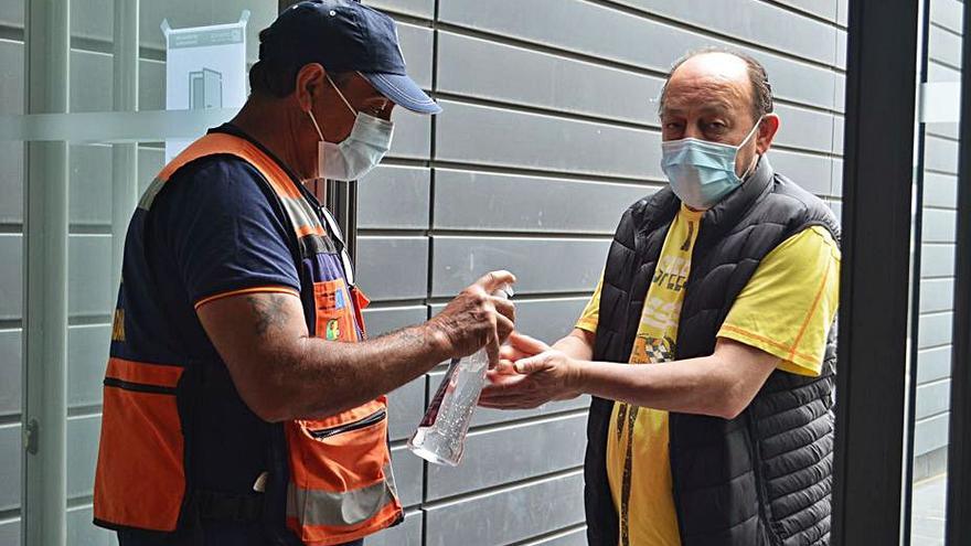 Un voluntario de Protección Civil dispensa gel hidroalcohólico a uno de los asistentes al Centro de Negocios. | E. P.