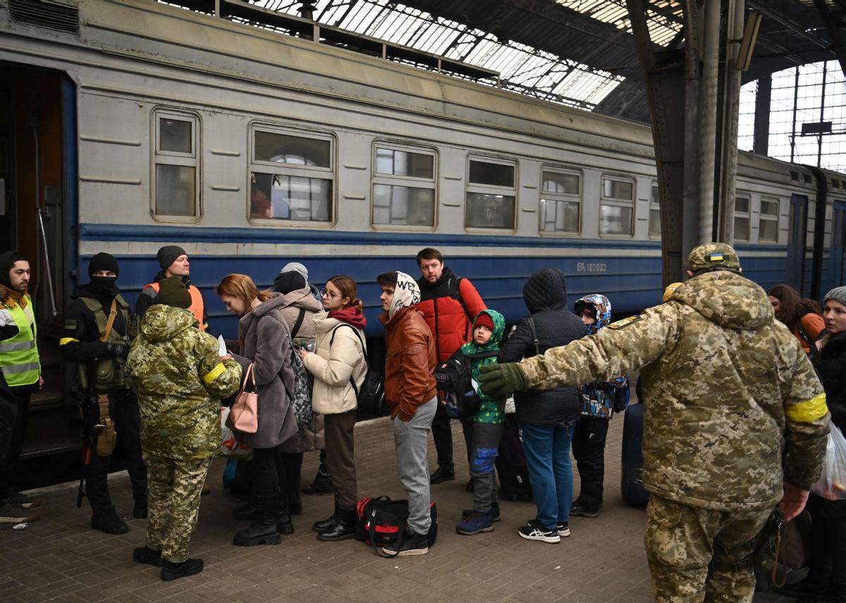 Un grupo de gente se dispone a embarcar en un tren en la estación de Leópolis, con destino a Polonia.